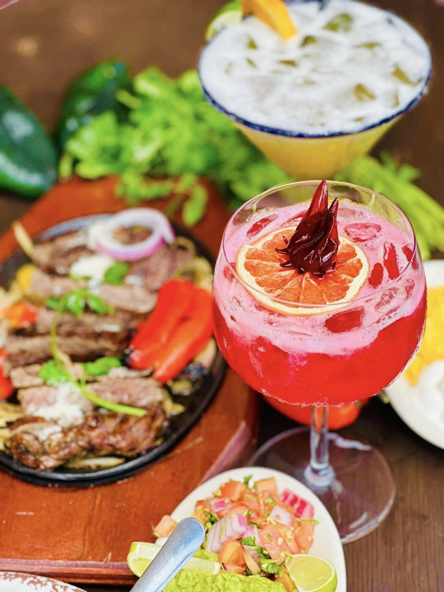 Sizzling steak fajita plate served with two cocktails