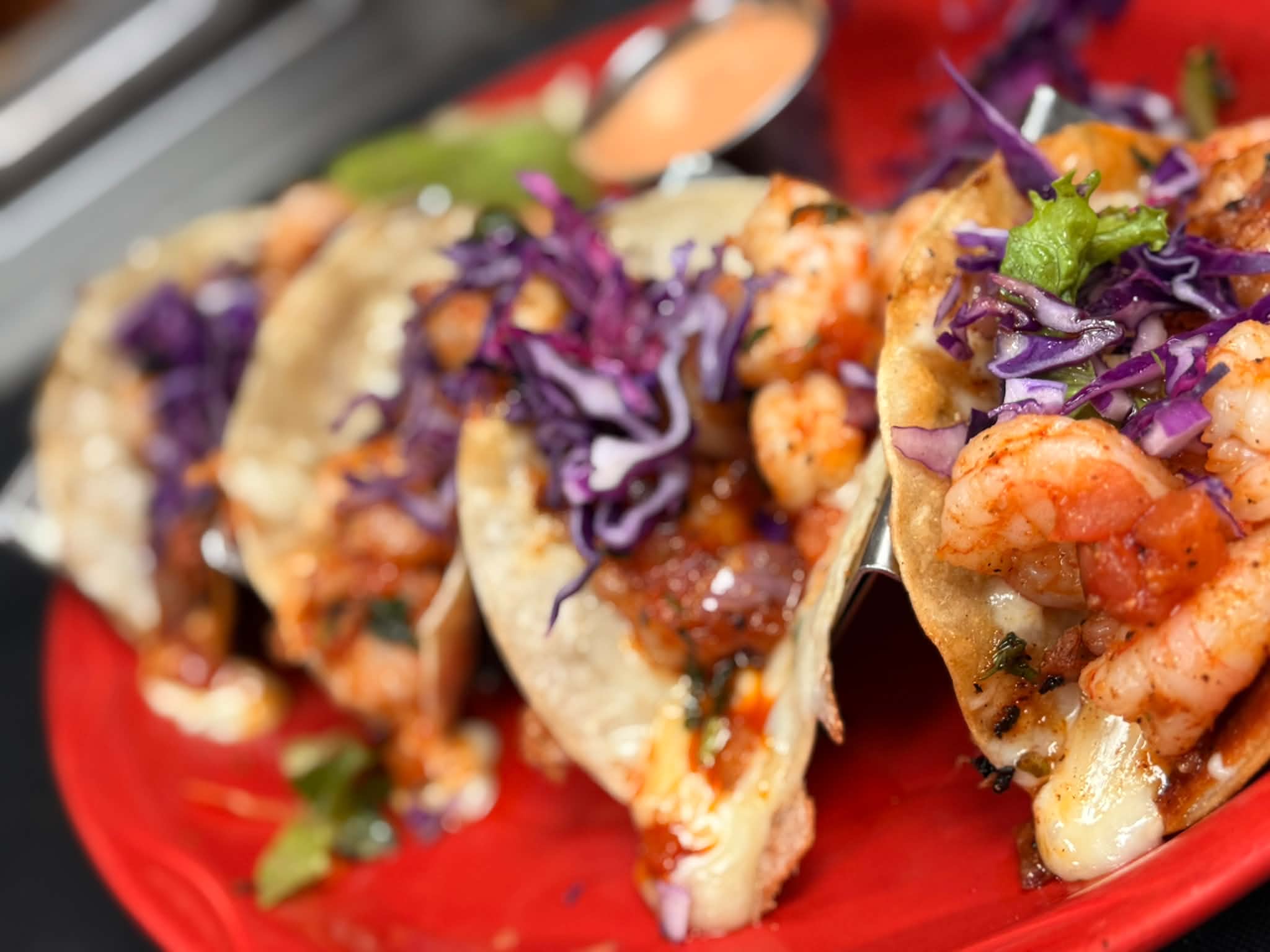 Shrimp tacos topped with red cabbage and chipotle sauce