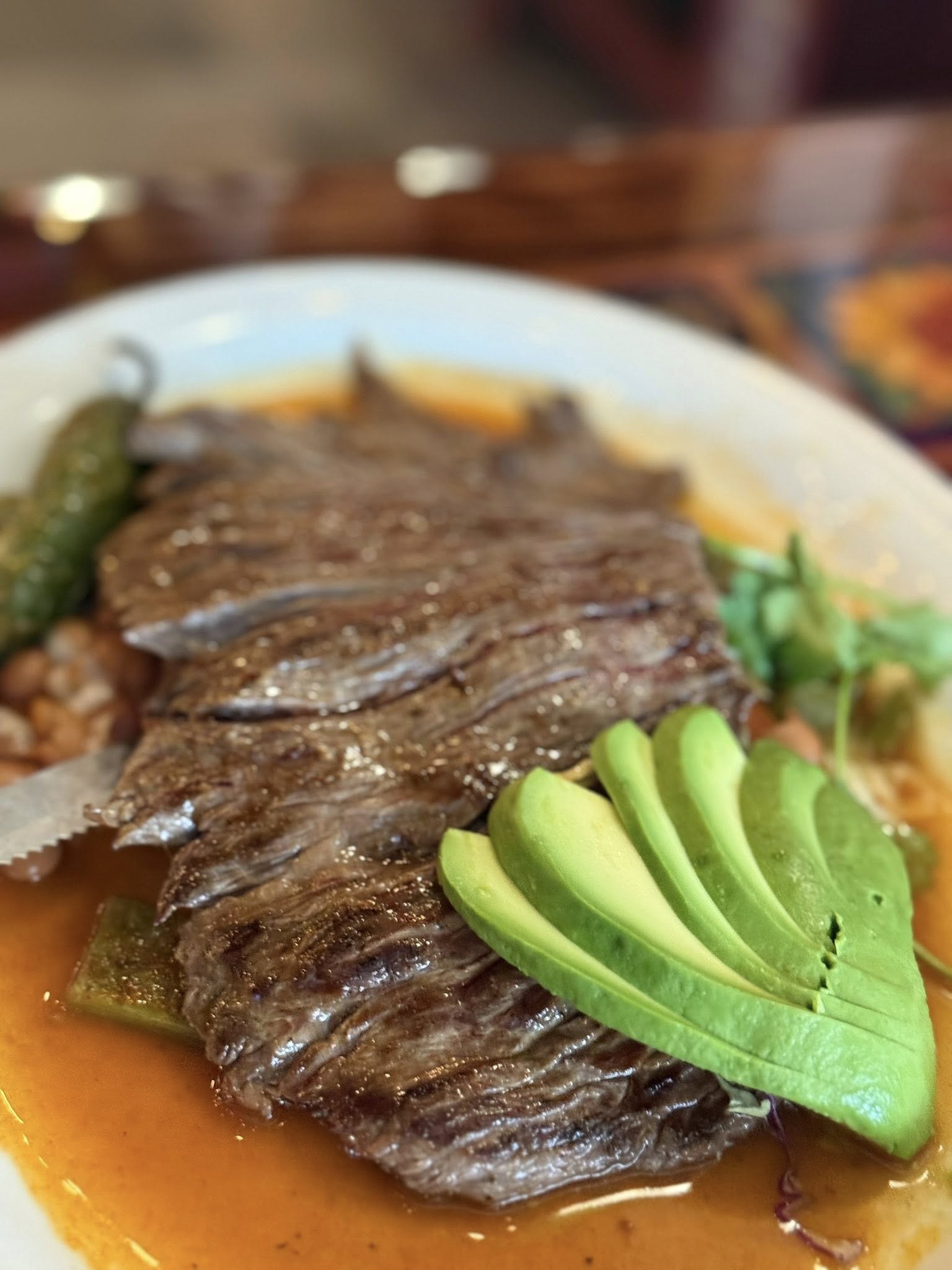 Sliced arrachera flank steak with a fan of avocado